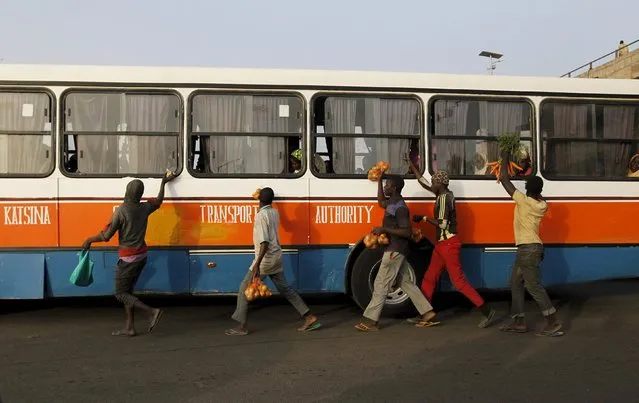 Hawkers run alongside a bus as they try to sell provisions to passengers in Zaria, Kaduna state, Nigeria, February 2, 2016. (Photo by Afolabi Sotunde/Reuters)