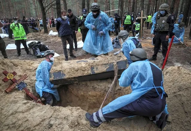 Members of Ukrainian Emergency Service, police and experts work at a place of mass burial during an exhumation, as Russia's attack on Ukraine continues, in the town of Izium, recently liberated by Ukrainian Armed Forces, in Kharkiv region, Ukraine on September 16, 2022. (Photo by Gleb Garanich/Reuters)