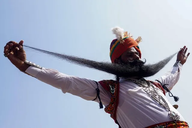 A man displays his moustache during a moustache competition at the annual fair at Pushkar, in India's Rajasthan state on November 22, 2023. (Photo by Himanshu Sharma/AFP Photo)