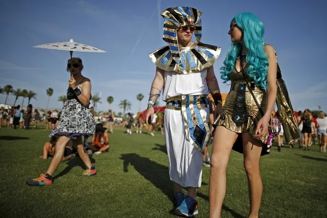 Drew Paterson, 31, (C) and Michelle Simone (R) walk through the Coachella Valley Music and Arts Festival in Indio, California April 10, 2015. (Photo by Lucy Nicholson/Reuters)