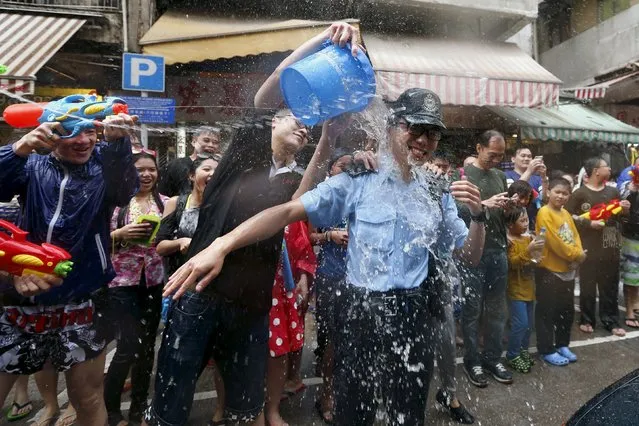 Water is thrown on a police at a water fight during Songkran Festival celebrations Kowloon City district, known as Little Thailand as there is large number of restaurants and shops run by Thais, April 12, 2015. (Photo by Tyrone Siu/Reuters)