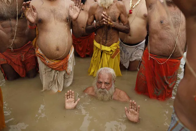 Members of the Hindu Brahmin community perform the annual 'Shravani Puja' at Sangam, the holy confluence of river Ganga, Yamuna and the mythical Sarawati, in Prayagraj, India. Sunday, August 22, 2021. The Shravani Puja is performed by the Brahmins on the day of Raksha Bandhan festival for washing away their sins committed all through the year. (Photo by Rajesh Kumar Singh/AP Photo)