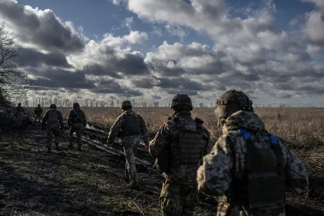 Ukrainian servicemen of the 55th Separate Artillery Brigade walk at a position near the front line town of Marinka, amid Russia's attack on Ukraine, in Donetsk region, Ukraine on December 26, 2023. (Photo by Viacheslav Ratynskyi/Reuters)