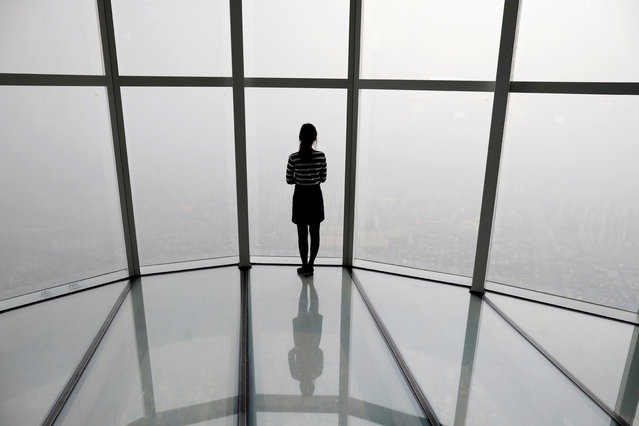 A woman looks at a view of Seoul shrouded by fine dust during a polluted day in Seoul, South Korea, March 6, 2019. South Korean President Moon Jae-in has proposed a joint project with China to use artificial rain to clean the air in Seoul, where an acute increase in pollution has caused alarm. (Photo by Kim Hong-Ji/Reuters)