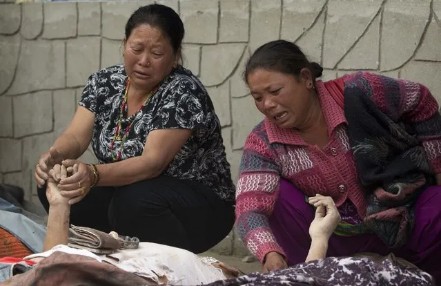 Unidentified relatives mourn near the bodies of those killed in earthquake at a hospital, in Kathmandu, Nepal, Sunday, April 26, 2015. (Photo by Manish Swarup/AP Photo)