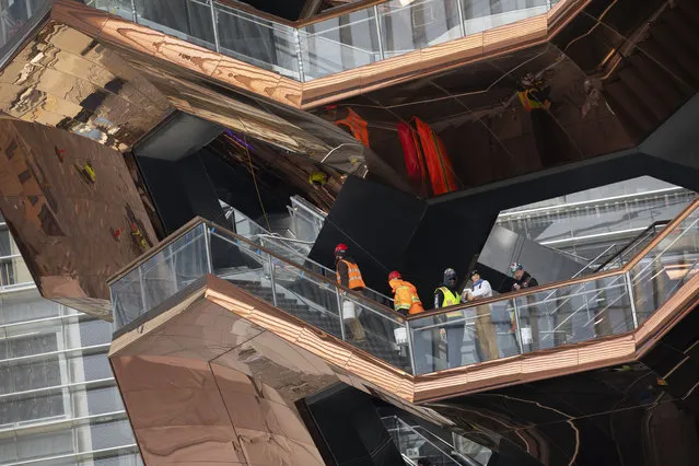 In this March 8, 2019 photo, workers climb the stairs of the “Vessel”, a 150-foot-tall structure in New York. The Thomas Heatherwick design opens to the public Friday, March 15, 2019. (Photo by Mark Lennihan/AP Photo)