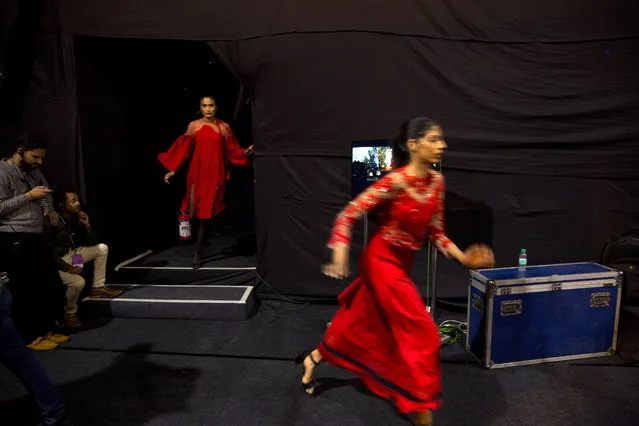 In this Wednesday, March 13, 2019, photo, models rush for a quick change of outfit in between a ramp walk during the Lotus Makeup India Fashion Week, in New Delhi, India. It's fashion season in India's capital city with the country's top designers showcasing their latest collections to lure the rapidly growing domestic and export markets for Indian haute couture. (Photo by Manish Swarup/AP Photo)
