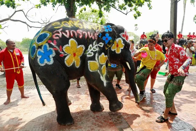 An elephant calf dances with people as part of celebrations for the water festival of Songkran in Ayutthaya, Thailand on April 11, 2019. (Photo by Soe Zeya Tun/Reuters)