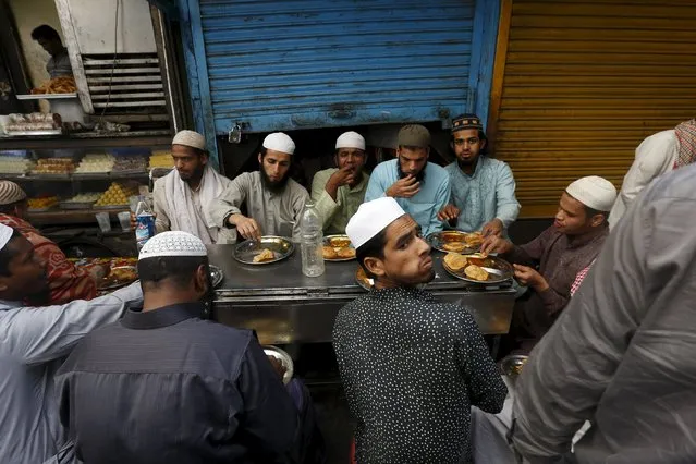 People eat their breakfast at a roadside shop outside the shrine of Muslim Sufi Saint Nizamuddin Auliya, in New Delhi, India, March 15, 2016. (Photo by Adnan Abidi/Reuters)