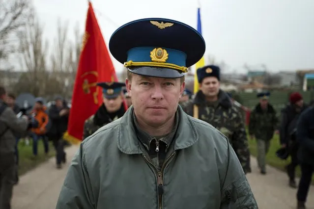 Col. Yuri Mamchur, commander of the Ukrainian garrison at the Belbek air base, lead his men to the base outside Sevastopol, Ukraine, Tuesday, March 4, 2014. Russian troops, who had taken control over Belbek airbase, fired warning shots in the air as around 300 Ukrainian officers marched towards them to demand their jobs back. (Photo by Ivan Sekretarev/AP Photo)