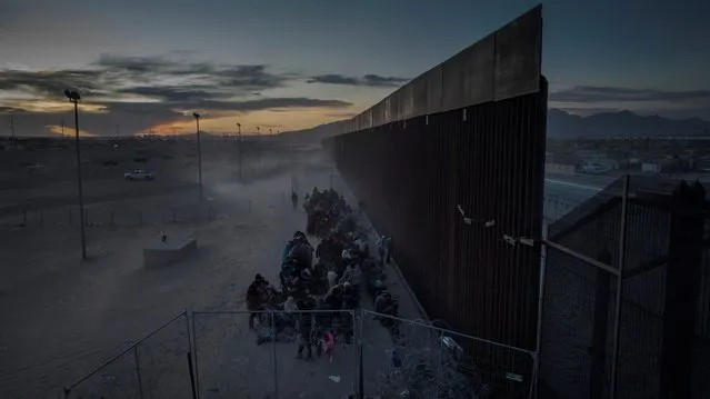 A drone view shows migrants enduring cold and blustery weather as they line up against the border wall to surrender to immigration officials after breaching a razor wire-laden fence along the bank of the Rio Grande River in El Paso, Texas, U.S., March 25, 2024. (Photo by Adrees Latif/Reuters)