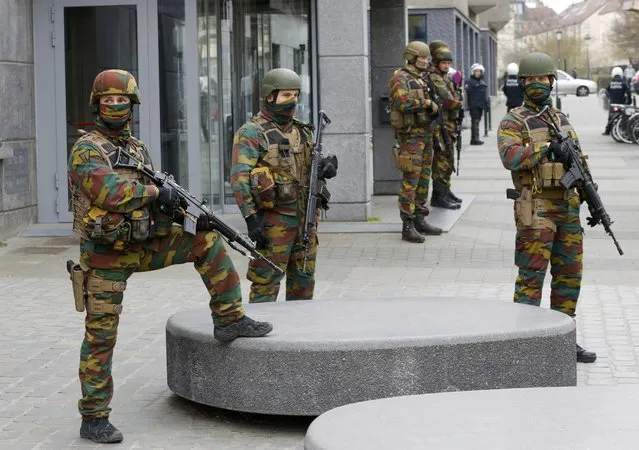 Soldiers stand guard as they take position outside town hall in the Brussels district of Molenbeek, Belgium, April 2, 2016. (Photo by Yves Herman/Reuters)