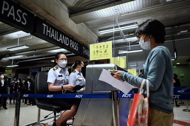 In this file photo taken on October 27, 2021, airport staff pretend to enter Thailand at the new entry lanes at Suvarnabhumi International Airport as they rehearse reopening procedures to welcome the first group of vaccinated tourists without quarantine, in Bangkok. Thailand on November 27, 2021 announced it would ban, from December, travellers from eight southern African countries where a new highly infectious Covid-19 strain has emerged. (Photo by Lillian Suwanrumpha/AFP Photo)