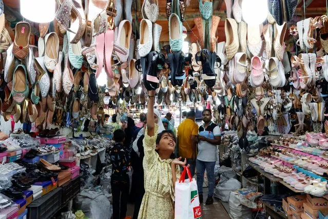 A girl looks at sandals for sale at a market ahead of the Eid al-Fitr festival, which marks the end of the Muslim fasting month of Ramadan, in Kolkata, India, on April 9, 2024. (Photo by Sahiba Chawdhary/Reuters)