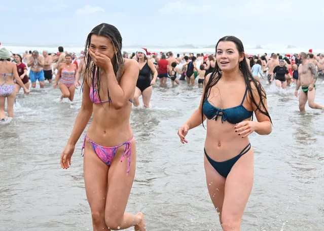 Hundreds of daring swimmers have braved freezing cold water for a festive dip on Christmas Day, December 25, 2021. In a tradition more than 50 years old, Cornwall residents stripped down to their swimsuits for an icy dip into the Atlantic. (Photo by PA Wire Press Association)