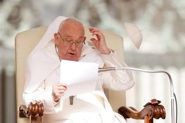 Wind blows Pope Francis' hat from his head during the weekly general audience in St. Peter's Square at the Vatican on April 10, 2024. (Photo by Remo Casilli/Reuters)