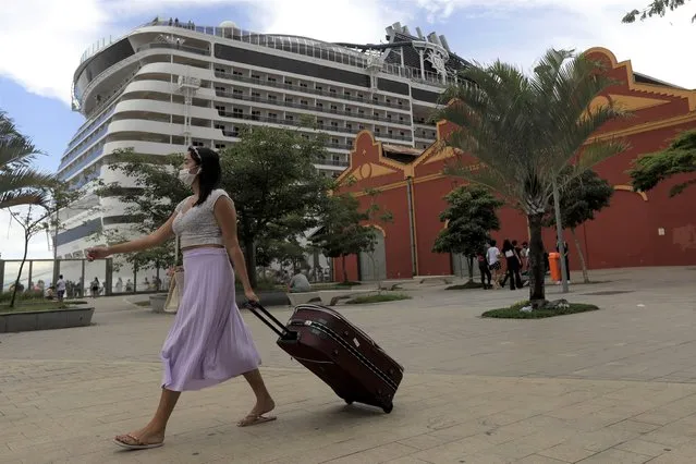 A passenger arrives to board at the cruise ship “MSC Preziosa”, in the Port Area of Rio de Janeiro, Brazil, Sunday, January 2, 2022, after Brazil's Sanitary Agency has confirmed more cases of COVID-19 on board. Rio's Health Secretariat said that those living in the city or nearby regions will be quarantined in their homes. Those who live outside the state will be isolated in hotels. (Photo by Bruna Prado/AP Photo)