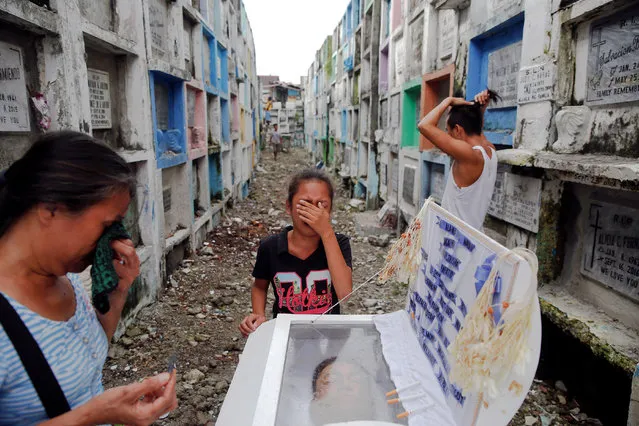 Kasandra Kate (C), 12, cries next to the coffin of her father Verigilio Mirano during his funeral at Navotas Public Cemetery in Manila, Philippines October 14, 2016. According to a family member, Mirano, who was using drugs but stopped after Rodrigo Duterte became the president, was killed by masked gunmen at his home on September 27th. (Photo by Damir Sagolj/Reuters)