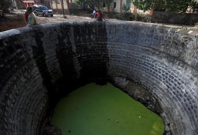 Women look into a partially dried-up well before fetching water from it in a neighbourhood in Thane district in Maharashtra, India, May 30, 2019. (Photo by Francis Mascarenhas/Reuters)