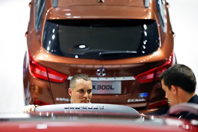 Visitors look on vehicles presented at the booth of Beijing Automotive Group (BAIC) during Auto China 2016 auto show in Beijing, China April 25, 2016. (Photo by Damir Sagolj/Reuters)