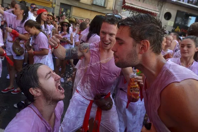 Revellers spit wine at each other during the start of the San Fermin festival in Pamplona July 6, 2015. (Photo by Vincent West/Reuters)
