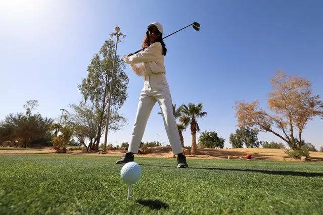 A Saudi woman positions herself before taking the shot during her training as part of the first professional Women Golf Team, in Riyadh Golf Club, Riyadh, Saudi Arabia, February 22, 2022. (Photo by Ahmed Yosri/Reuters)