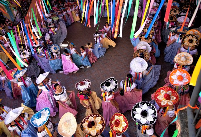 Women in traditional dress dance to celebrate El Dia de la Candelaria, or Candelaria Day, in San Fernando, Chiapas, Mexico, 02 February 2023. Women dressed in zoque dresses and charro hats for a three-day celebration involving dance to drums and reed flutes. (Phptp by Carlos Lopez/EPA)