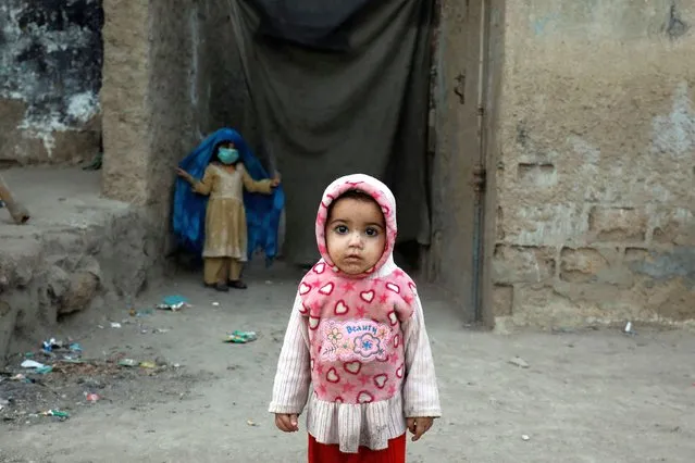 One year-old Zainab stands at the entrance of her family home in a slum in Karachi, Pakistan on February 15, 2022. (Photo by Akhtar Soomro/Reuters)