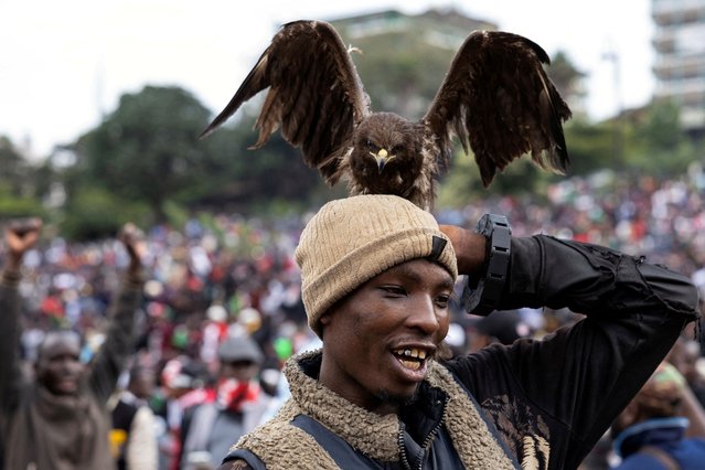 A bird of prey sits on a man's head at a tribute concert held in honour of the people killed in anti-government protests, in Nairobi, Kenya on July 7, 2024. (Photo by James Oatway/Reuters)