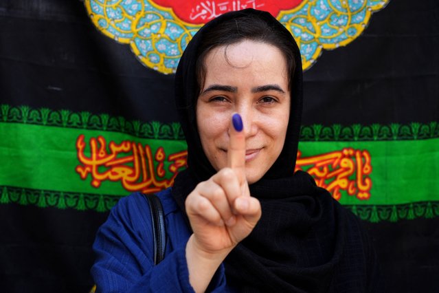 An Iranian woman displays her ink-stained finger after casting her ballot at a polling station in Qarchak Varamin southwestern of Tehran on July 5, 2024. Polls opened on July 5 for Iran's runoff presidential election, the interior ministry said, pitting reformist candidate Masoud Pezeshkian against ultraconservative Saeed Jalili in the race to succeed Ebrahim Raisi, who died in a May helicopter crash. (Photo by Raheb Homavandi/AFP Photo)