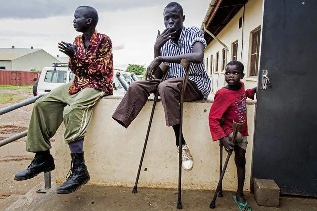 Seven year old amputee, Deng (R), SPLA soldier Kong (C) and Mabior (L) are pictured at the Rehabilitation Centre of Juba, South Sudan, on October 10, 2012. Deng was amputated when he was 4 years old after a mine he was playing with, blew up in his house, killing his mother. Kong stepped on a mine in Upper Nile state early 2012 and Mabior lost his leg at war. (Photo by Camille Lepage/AFP Photo)