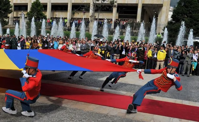 Members of the Colombian presidential guard perform during the ceremony in which Colombian President Juan Manuel Santos gave the national flag to the squad ahead of the FIFA World Cup Brazil 2014 tournament, at Narino presidential palace in Bogota, on May 23, 2014. The team is heading to Argentina to play friendly matches against Senegal and Jordan as part of their preparation for the upcoming World Cup. (Photo by Guillermo Legaria/AFP Photo)