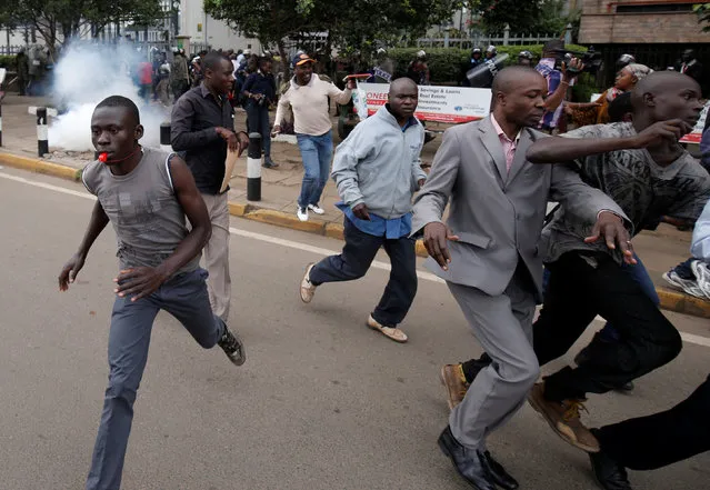 Supporters of Kenya's opposition Coalition for Reforms and Democracy (CORD) run away after riot police lobbed teargas canisters to disperse them during a protest at the premises hosting the headquarters of Independent Electoral and Boundaries Commission (IEBC) to demand the disbandment of the electoral body ahead of next year's election in Nairobi, Kenya, May 23, 2016. (Photo by Goran Tomasevic/Reuters)