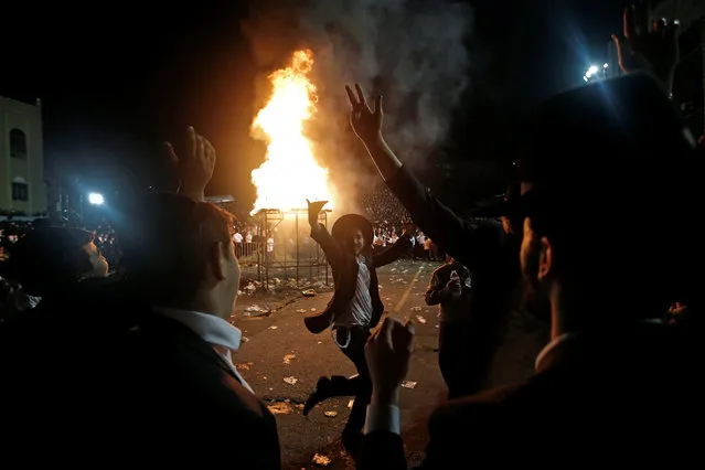 Orthodox Jews of the Satmar Hasidim dance near a bonfire as they celebrate the Jewish holiday of Lag Ba'Omer which marks the anniversary of the death of Talmudic sage Rabbi Shimon Bar Yochai approximately 1,900 years ago, in the village of Kiryas Joel, New York, U.S., May 25, 2016. (Photo by Mike Segar/Reuters)