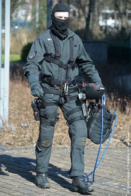 A Member of Germany's elite police unit, the Spezialeinsatzkommando, or SEK, leaves the building after demonstrating an abseil deployment from a helicopter during a media event