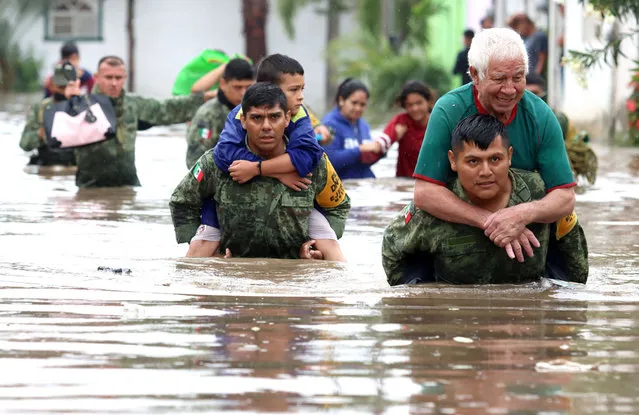 Members of the Mexican Army rescue people who were trapped in flooded houses after heavy rains in Tlaquepaque, Jalisco state, Mexico, on September 3, 2021. (Photo by Ulises Ruiz/AFP Photo)