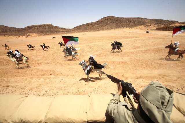 A group of regional bedouin actors in historical military costumes re-enact the events of the “Great Arab Revolt” that broke out in 1916, when this desert witnessed the Bedouin population joining the Arab forces led by King Faisal to fight the Ottoman army between 1916 and 1918, performing on May 06, 2023 in Wadi Rum, Jordan. The Hejaz Railway was built by Ottoman ruler Sultan Abdulhameed in 1909 and destroyed during the Arab Revolution attack against the Ottoman Empire. It became a UNESCO World Heritage Site due to its importance as a route for the yearly Islamic pilgrimage to the Holy city of Makkah. (Photo by Salah Malkawi/Getty Images)