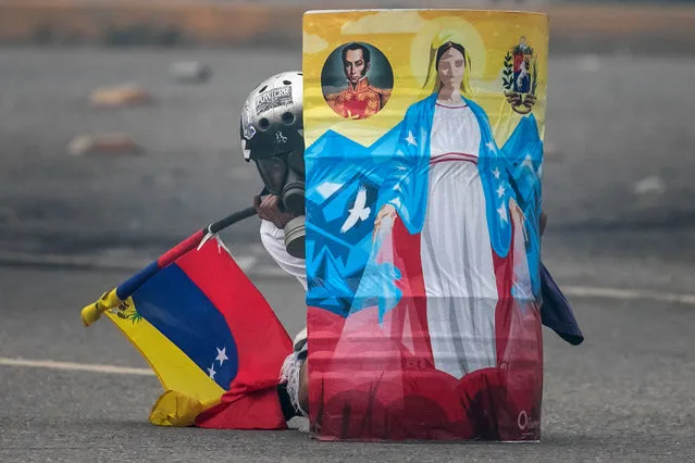 An opposition protester hides behind a handmade shield during a protest in Caracas, Venezuela, 07 June 2017. The death of a 17-year old after being wounded during today's anti-government protest at the Venezuelan capital was confirmed by the Attorney's Office. (Photo by Miguel Gutierrez/EPA)