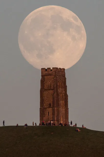 The moon rises over people gathered on Glastonbury Tor ahead of tomorrow's Blue Moon on July 30, 2015 in Somerset, England. (Photo by Matt Cardy/Getty Images)