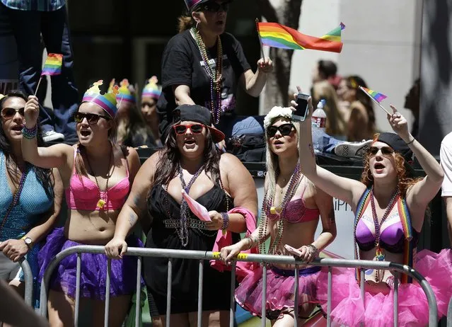 People lining Market Street watch the 44th annual San Francisco Gay Pride parade Sunday, June 29, 2014, in San Francisco. The lesbian, gay, bisexual, and transgender celebration and parade is one of the largest LGBT gatherings in the nation. (Photo by Eric Risberg/AP Photo)