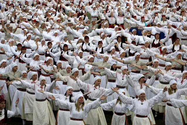 Dancers wear traditional dresses as they perform during women's dance festival in Jogeva, Estonia, June 12, 2016. (Photo by Ints Kalnins/Reuters)