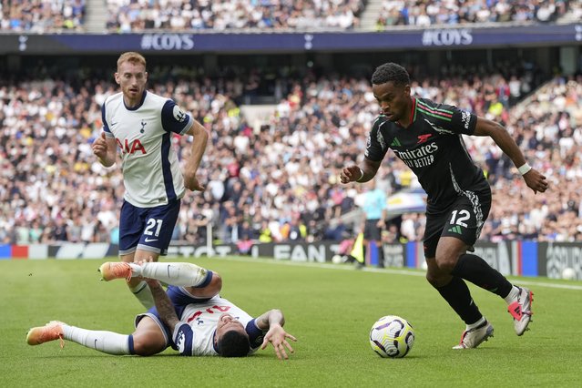 Arsenal's Jurrien Timber, right, runs with the ball after a challenge with Tottenham's Pedro Porro during the English Premier League soccer match between Tottenham Hotspur and Arsenal in London, Sunday, September 15, 2024. (Photo by Kin Cheung/AP Photo)