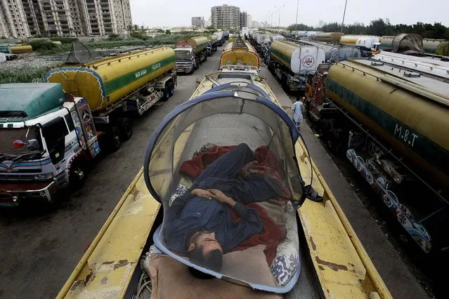 A man takes a nap on an oil tanker used to transport NATO fuel supplies to neighboring Afghanistan, in Karachi, Pakistan on May 17, 2012