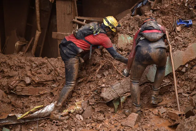 Firefighters search for missing persons after a landslide in Vila Bernadete, Belo Horizonte, Minas Gerais state, Brazil, on January 26, 2020. A landslide buried several houses in Vila Bernadete Friday, leaving 4 dead and 7 missing. Two days of torrential rains in Minas Gerais state have left at least 30 people killed, several injured, 17 missing and more than 2,500 homeless following a series of landslides and house collapses, Civil Defence officials said. (Photo by Douglas Magno/AFP Photo)