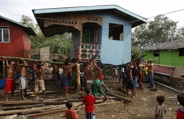 Residents lift a house damaged by Typhoon Rammasun (locally named Glenda) in a coastal village of sea gypsies, also known as Badjaos, in Batangas city, south of Manila, July 17, 2014. The Philippines set to work clearing debris, reconnecting power and rebuilding flattened houses on Thursday after the typhoon swept across the country killing 38 people, with at least eight missing, rescue officials said. (Photo by Erik De Castro/Reuters)