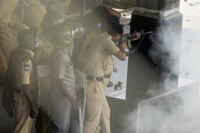 Policemen open fire to disperse protestors during a demonstration against the government's new “Agnipath” recruitment scheme for the army, navy, and air forces at a railway station in Secunderabad on June 17, 2022. (Photo by Noah Seelam/AFP Photo)