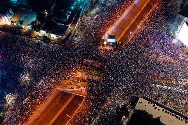 An aerial picture shows Israeli demonstrators raising banners and waving flags during a rally in Tel Aviv to protest the Israeli government's judicial overhaul plan, on July 1, 2023. (Photo by Gil Cohen-Magen/AFP Photo)