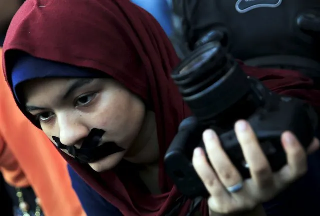 A news photographer with her mouth taped and holds up her camera during a protest against the detention of Ahmed Ramadan, a photojournalist with Egyptian private newspaper “Tahrir”, in front of the Syndicate of Journalists in Cairo, Egypt August 17, 2015.  Ramadan was released on bail late Monday following his arrest on Sunday on accusations that he was a member of the Muslim Brotherhood, local media reported. (Photo by Amr Abdallah Dalsh/Reuters)