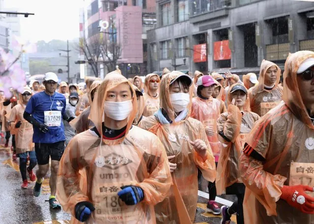 In this February 16, 2020, photo, runners, some wearing masks, compete in a Kumamoto castle marathon in Kumamoto city, western Japan. Organizers of the Tokyo Marathon set for March 1, 2020 are drastically reducing the number of participants out of fear of the spread of the coronavirus from China. The general public is essentially being barred from the race. (Photo by Kyodo News via AP Photo)