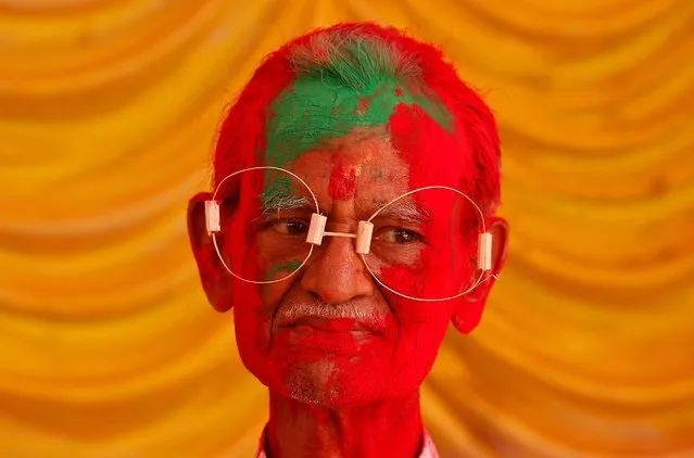 A man, with his face daubed in colours, wears eye frames made of bamboo straw during Holi celebrations in Chennai, India, March 10, 2020. (Photo by P. Ravikumar/Reuters)
